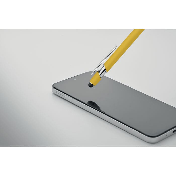 A yellow stylus rests on a sleek black smartphone, highlighting its shiny surface. The smartphone has a silver edge.