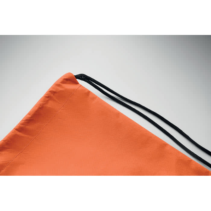 An orange drawstring bag with a black cord. It features a textured surface and is partially displayed.