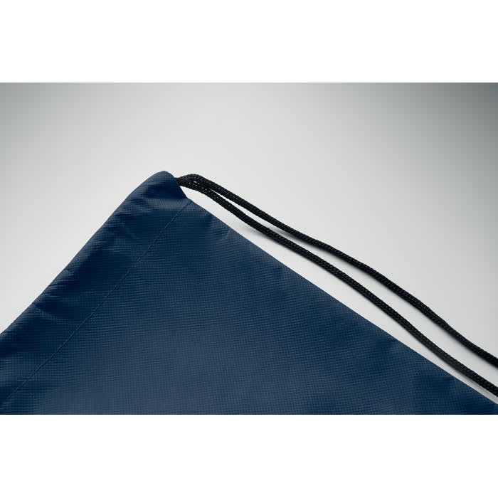 A drawstring bag in navy blue with a black cord detail at the opening and a branded logo.