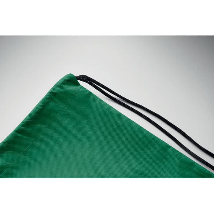 A green drawstring bag with a textured surface and black cord drawstring. It has a corner feature visible in the image.