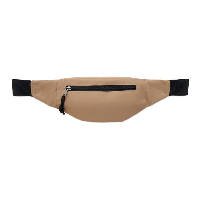 A hip bag in a tan colour with a black zipper and adjustable strap. It features a single front pocket.