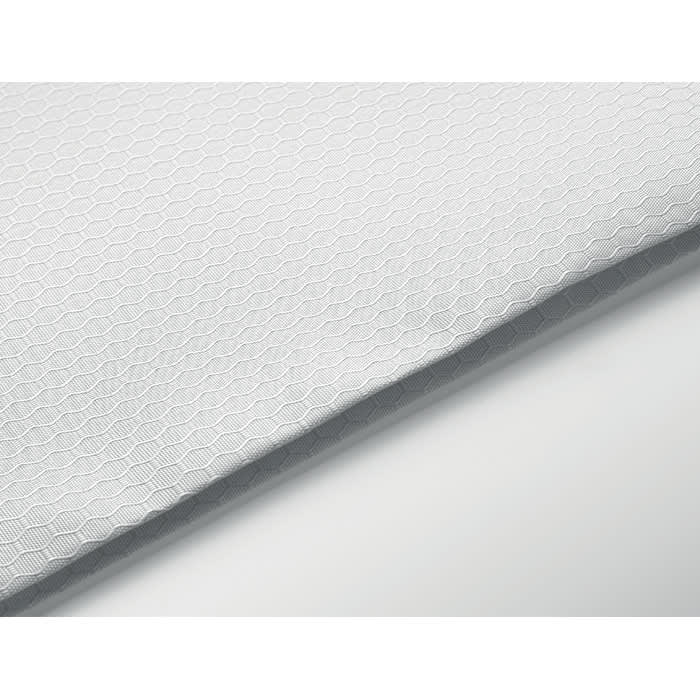 A textured white fabric featuring a hexagonal pattern, lying flat against a smooth surface.