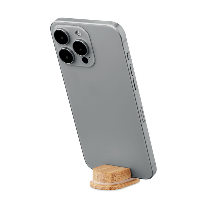 A phone in a grey case, angled on a small bamboo stand, featuring three rear camera lenses.