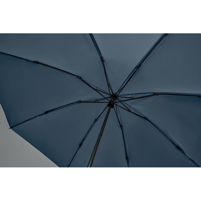 A dark blue umbrella viewed from underneath, showcasing the support ribs and shaft structure.
