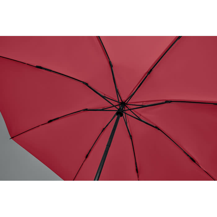 A red umbrella with black ribs and a central hub, showcasing its interior structure.