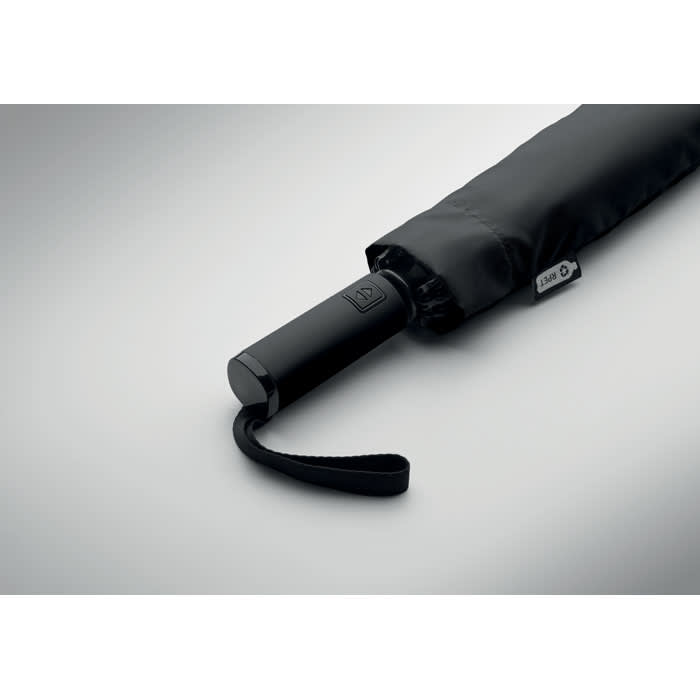 A black umbrella with a handle and a strap, featuring a logo on the handle.