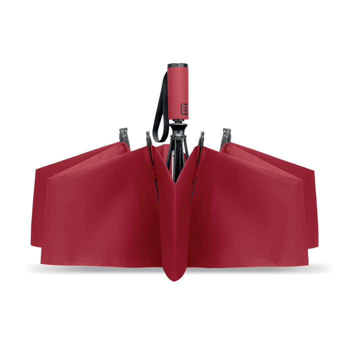 A red umbrella with a compact handle and a unique design, featuring a logo on the handle.