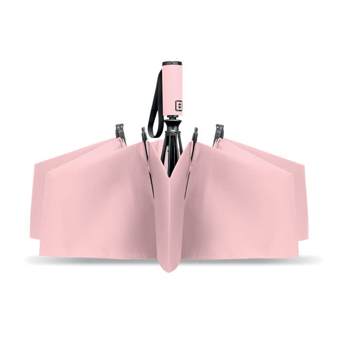 A pink umbrella folded with a black handle, featuring a strap and a simple design.