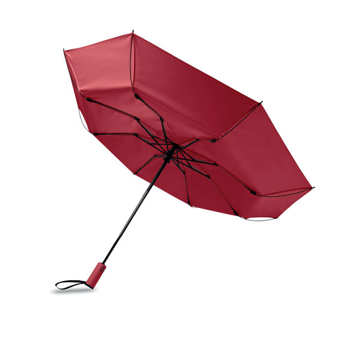 A red umbrella with a black handle and spokes, featuring a compact design and a logo on the handle.