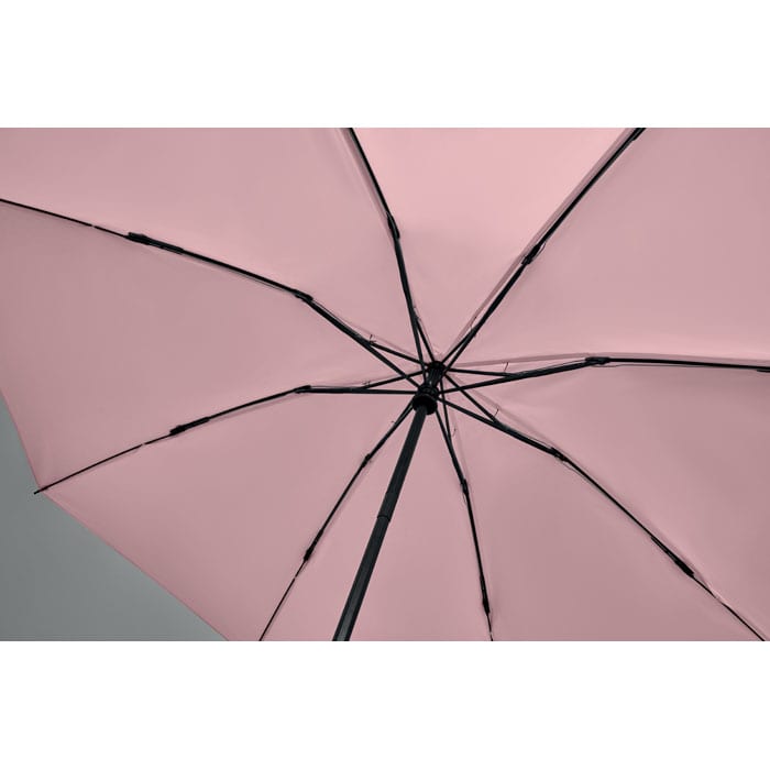 A pink umbrella with black detailing, showing the underside and structural elements.