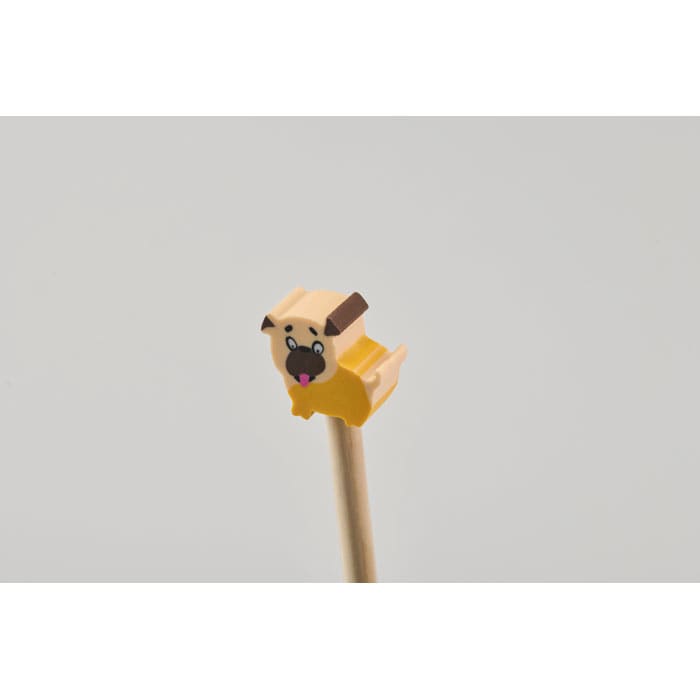 A yellow dog-shaped pencil topper with a playful expression attached to a wooden pencil.