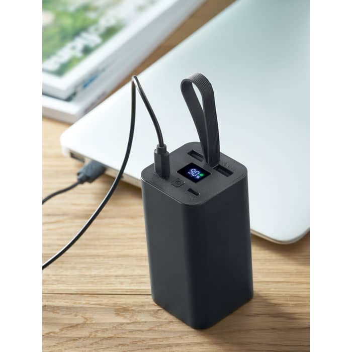 A power bank in black with a digital display, featuring multiple USB ports and a carry strap.