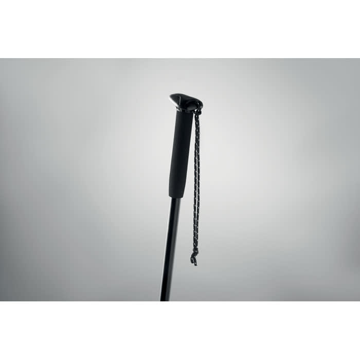 A black walking stick with a rubber grip and a decorative chain attached to the handle.
