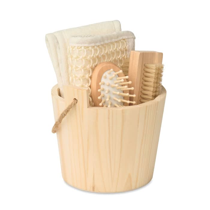 A wooden bucket containing natural-toned towels and various wooden hair care tools.