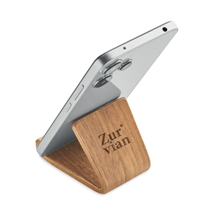 A phone stand made of wood, featuring a sleek design with a silver phone positioned on it. It has a logo.