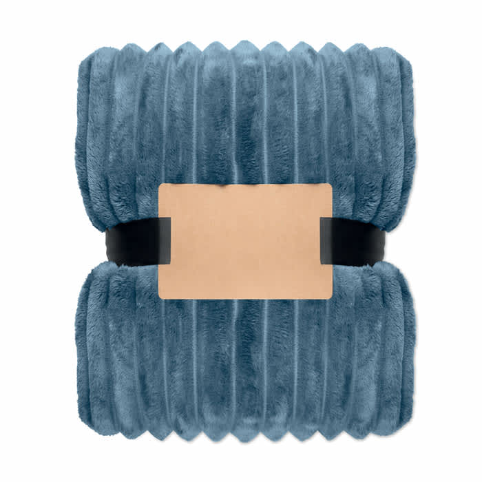 A plush blue blanket neatly folded and secured with a black band, featuring a blank label in the centre.