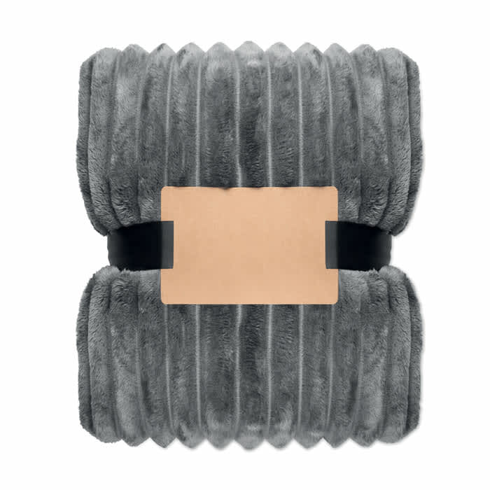 A plush grey throw blanket with a ribbed texture, secured with a black band. The blanket has a plain label in the centre.