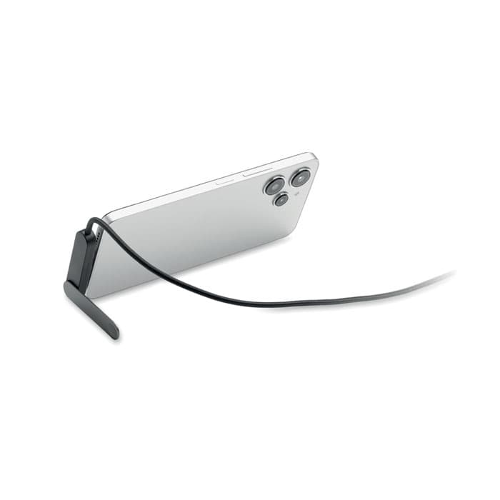 A mobile phone with a silver back, propped up by a black stand and a black strap attached.