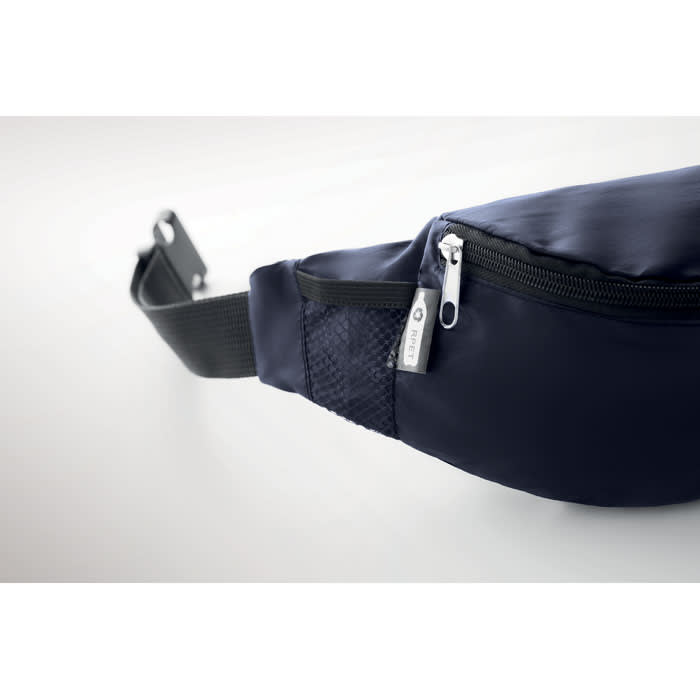 A navy waist bag with a zippered pocket and mesh details, featuring a logo on the zipper.