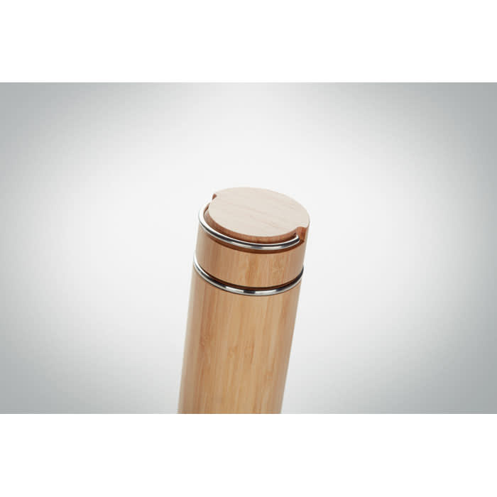 A drink bottle in bamboo finish with a metal band and a wooden cap. Features a sleek, minimalist design.