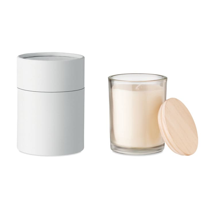 A candle in a transparent glass container with a wooden lid, alongside a plain white cylindrical holder.