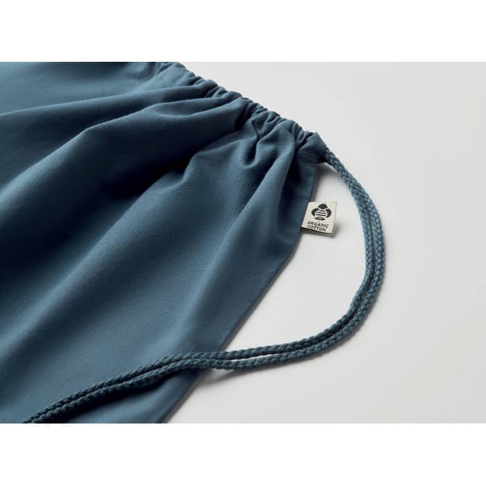 A drawstring bag in a soft blue colour with a braided cord and a small logo tag.