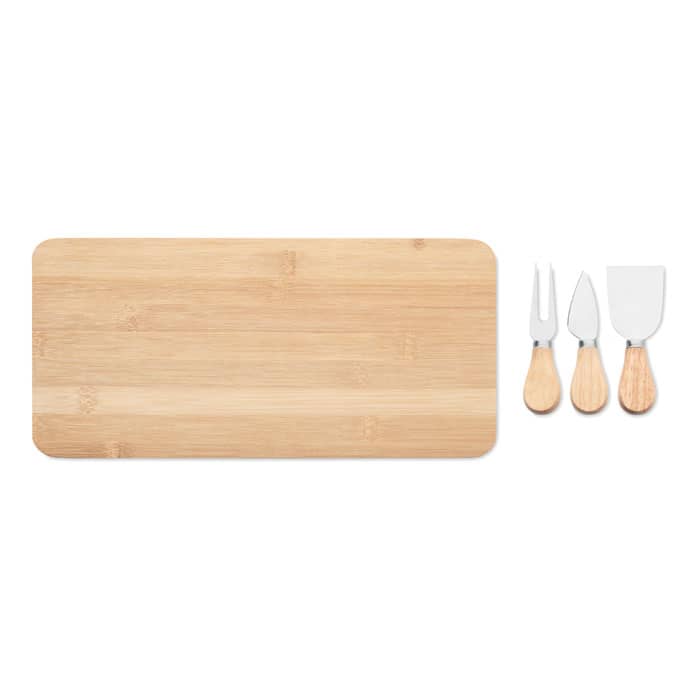 A bamboo cheese board accompanied by three stainless steel cheese utensils with wooden handles.