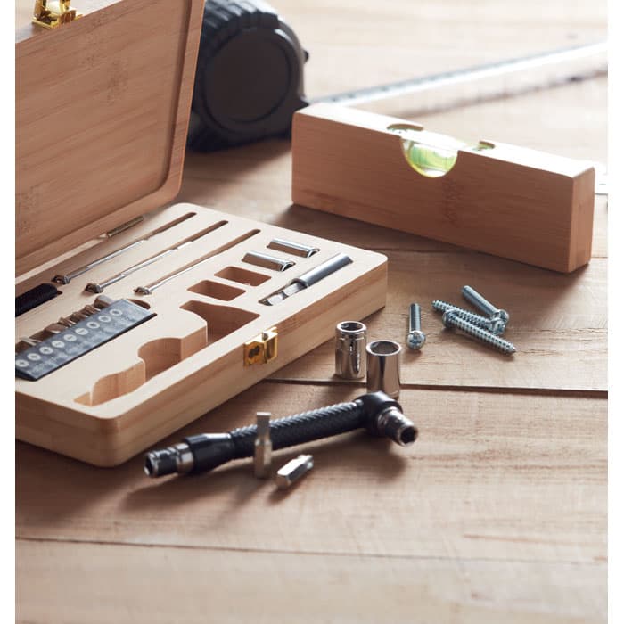 A tool set in a bamboo case, featuring various screws, sockets, and a spirit level on a wooden surface.