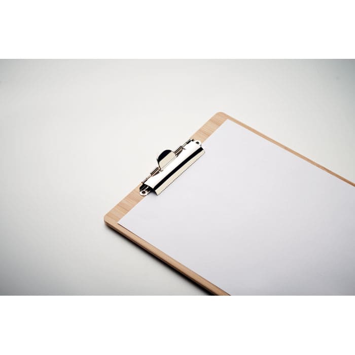 A clipboard with a wooden backing and a silver clip holds a blank sheet of white paper.