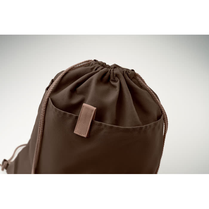 A brown drawstring bag with a leather accent and matching cords, featuring a gathered top closure.