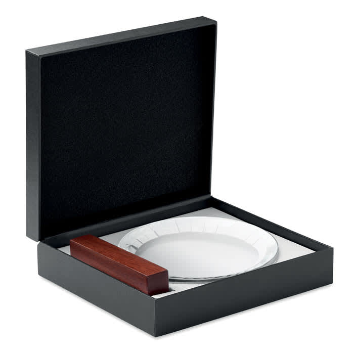 A gift box containing a glass plate and a wooden holder, with a black exterior and white interior.
