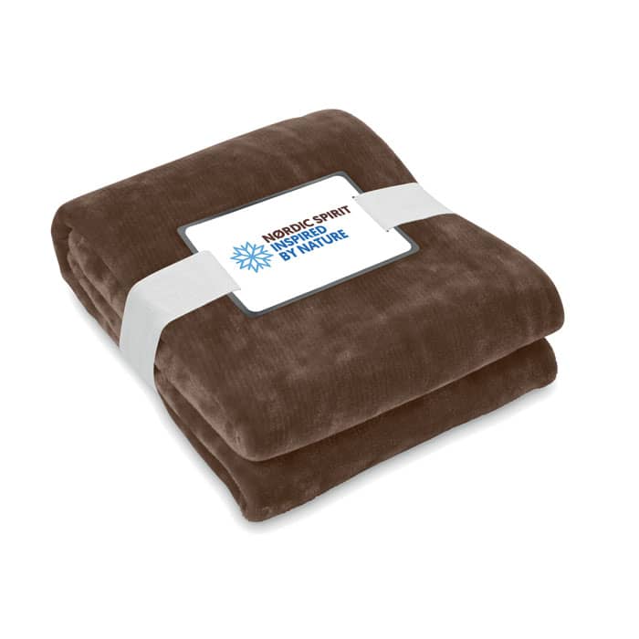 A brown fleece blanket neatly folded and secured with a white band, featuring a logo on the front.