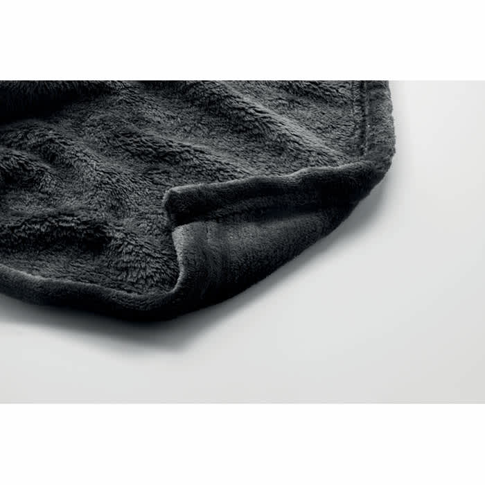 A soft, dark grey blanket with a textured surface is folded at the edge. It features a smooth border.