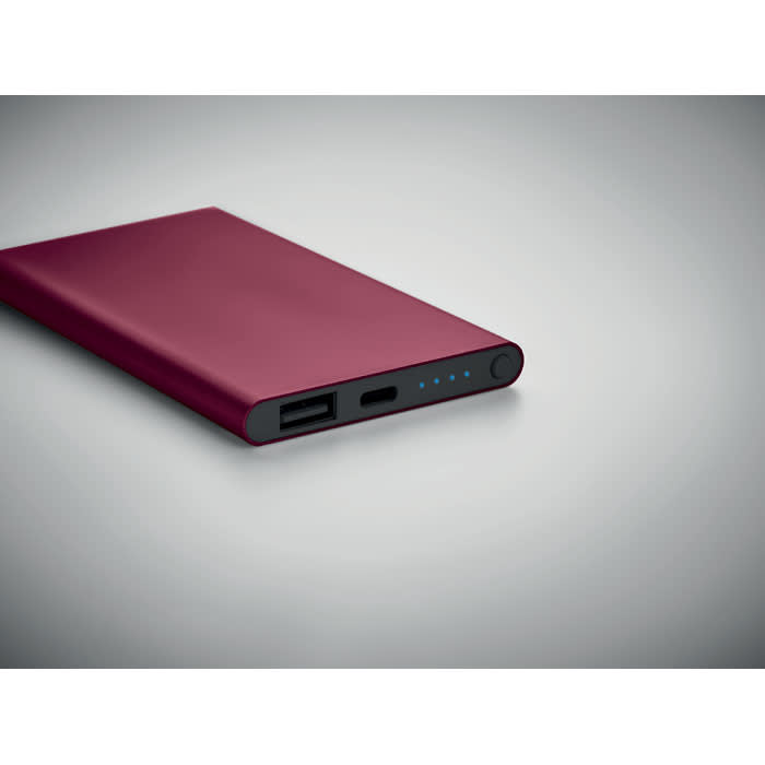 A power bank in a deep burgundy colour, featuring USB and USB-C ports and battery indicator lights.