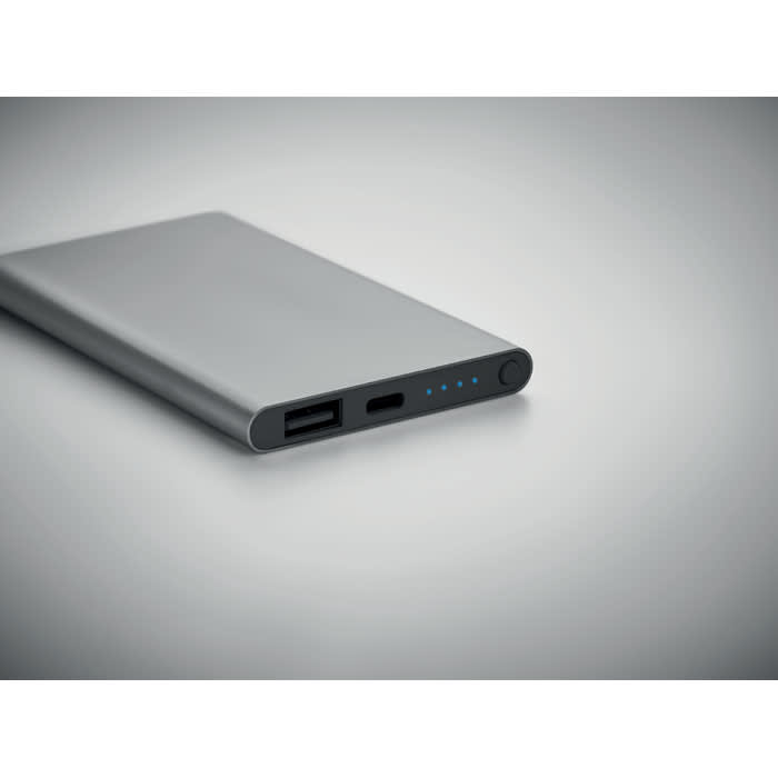 A power bank in silver, featuring a USB port and a USB-C port, with LED indicators on one side.