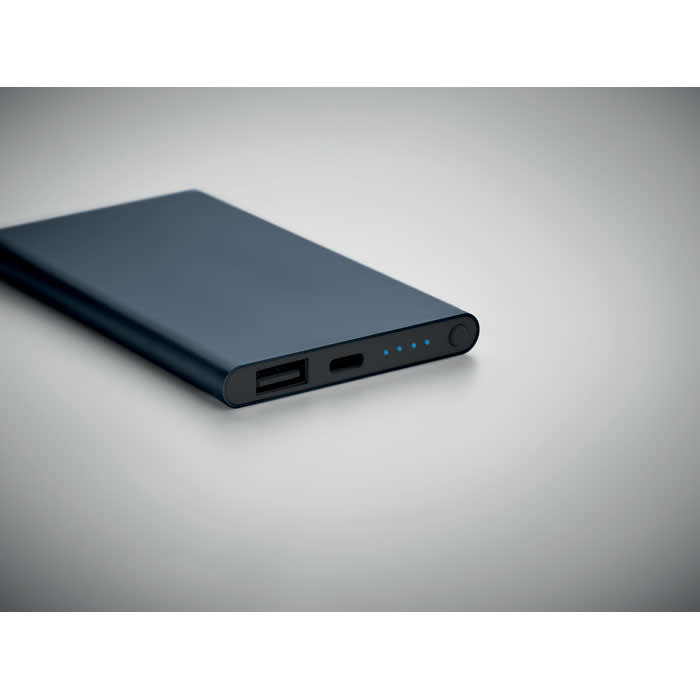 A portable power bank in navy blue with USB ports and indicator lights on the side.