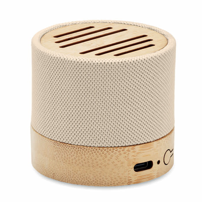 A cylindrical speaker featuring a beige mesh exterior with a bamboo base and a USB port.