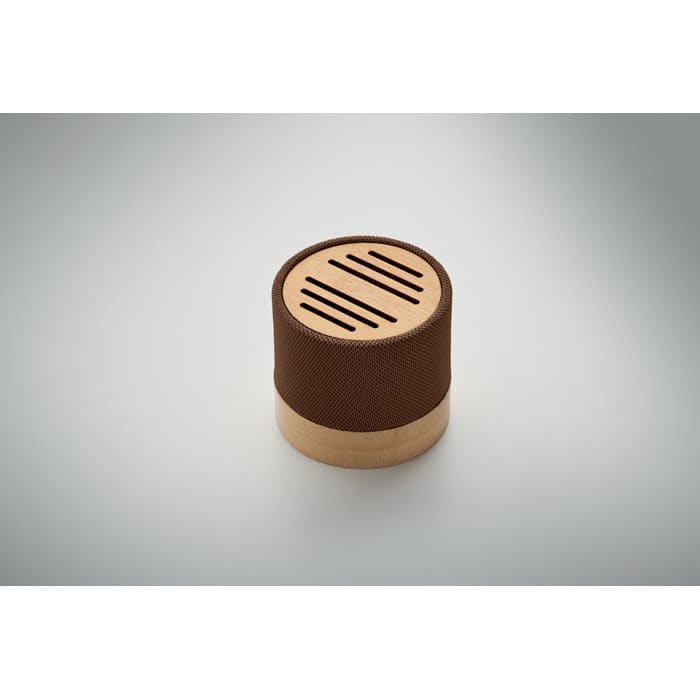 A round brown speaker with a wooden base, featuring a slotted top design. It includes a logo on the surface.