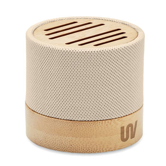 A portable speaker featuring a beige fabric mesh cover and a natural wood base, with ventilation slots on top.