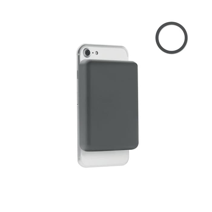 A phone card holder in dark grey, designed to attach to a smartphone, with a circular rubber ring beside it.