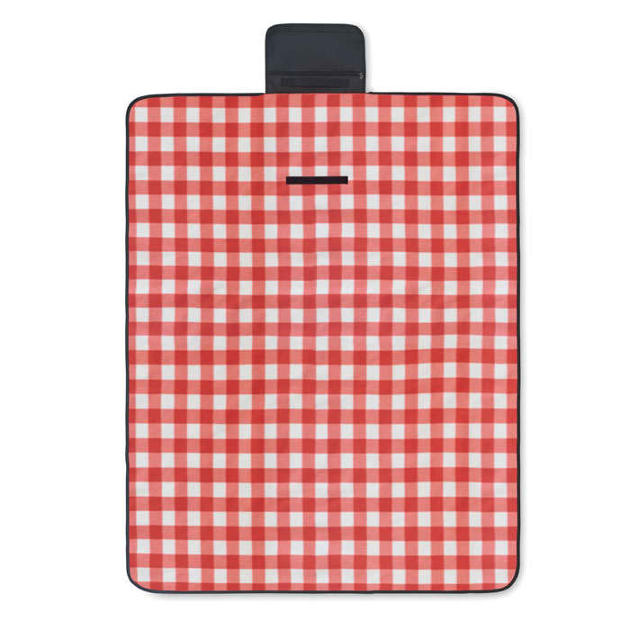 A picnic mat with a red and white checkered pattern, featuring a black carrying handle. It has a rectangular shape and padded surface.