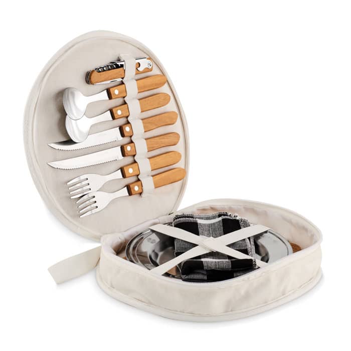 A picnic set in a round cream case, featuring metal utensils with wooden handles and a checkered cloth inside.