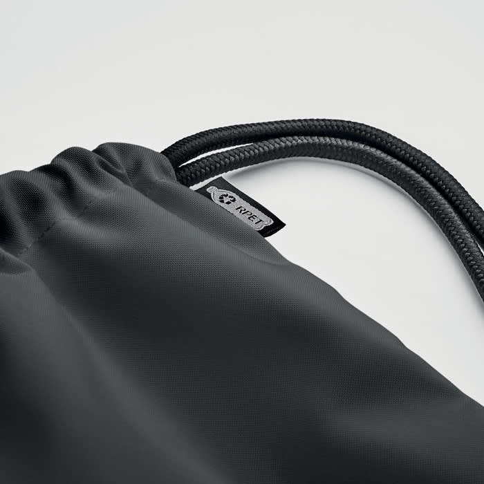 A drawstring bag in black fabric with a textured surface, featuring a logo tag on the side.