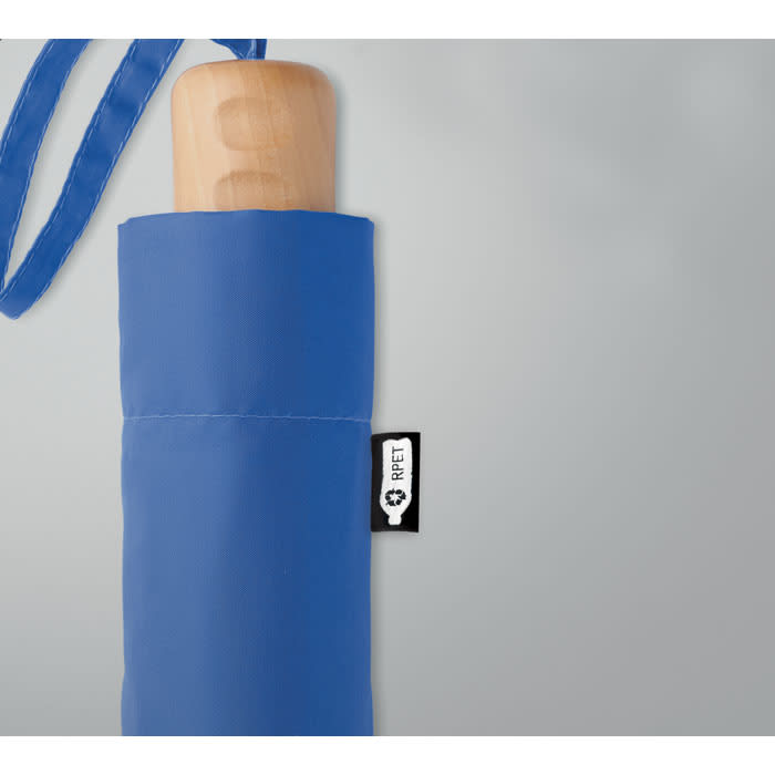 A blue umbrella with a wooden handle and a fabric sleeve, featuring a small logo.