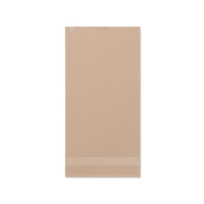 A yoga mat in a soft beige colour, featuring a smooth texture and a subtle logo at the top.