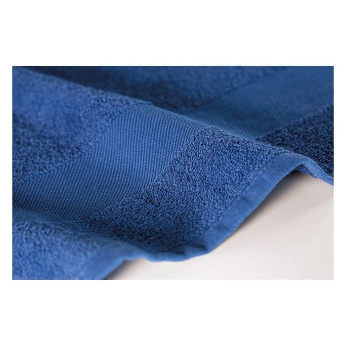 A blue towel with textured stripes displayed flat on a surface, showcasing its thick, plush fabric.