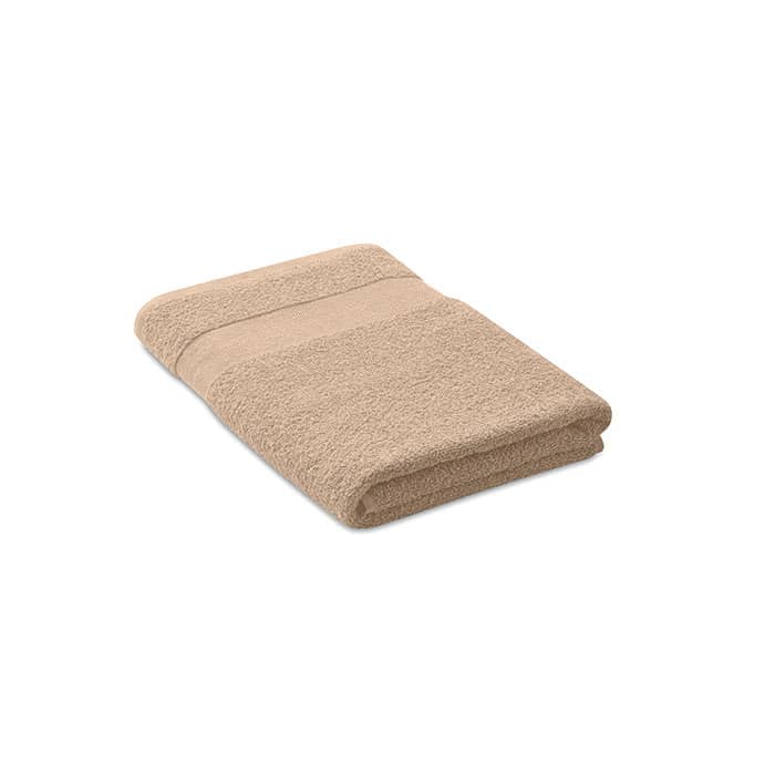 A folded beige towel with a textured surface and a smooth band across the centre. Features a logo on one corner.