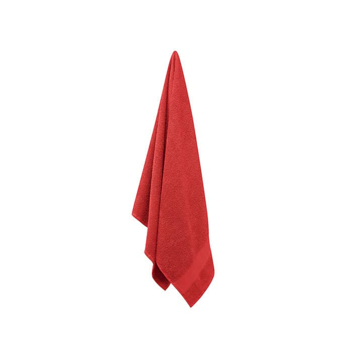 A red towel hanging, made of soft fabric, with a textured finish and a hemmed edge.