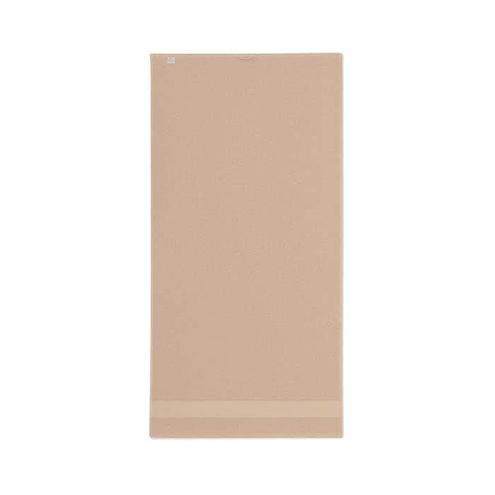 A yoga mat in a soft beige colour, featuring a textured surface and a subtle logo at the top.