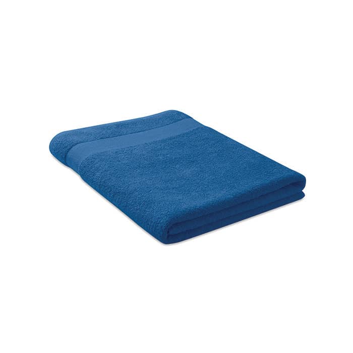 A folded towel in a vibrant shade of blue with a textured stripe across the top.